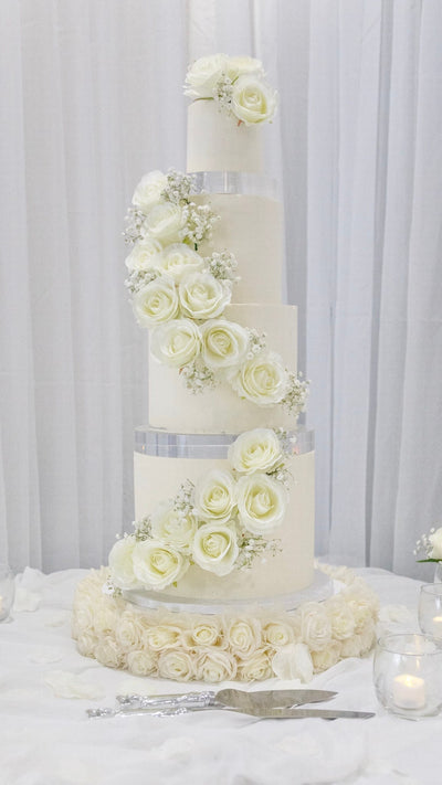 Four-tier wedding cake with white roses