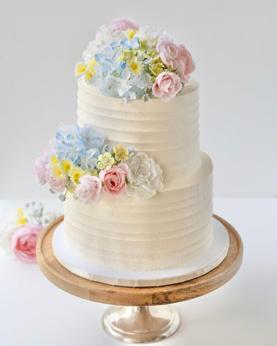 Two-tier wedding cake decorated with pastel flowers