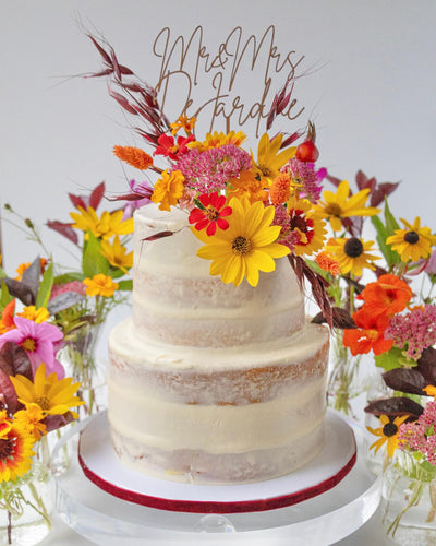 Two-tier wedding cake decorated with colourful flowers